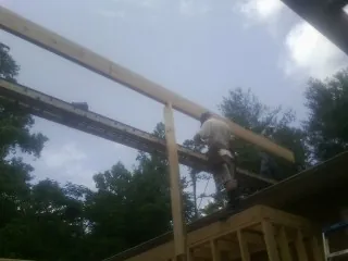 Carpenter setting a ridge beam over a new addition frame — Ice Dam Removal by Roofing Brothers in Asbury Park