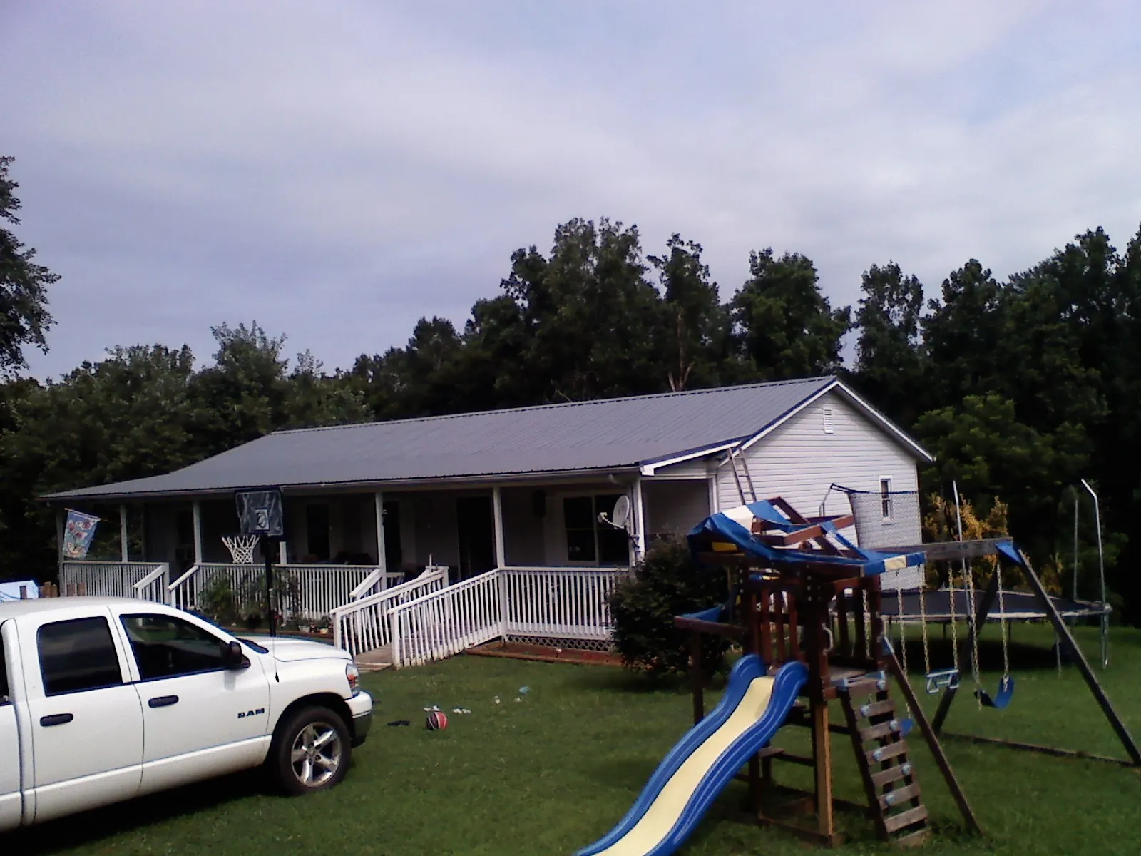 Dark metal roof on a country home with a full length front porch in Asbury Park