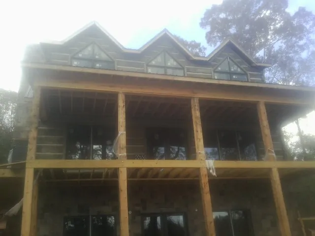 Dormers and porch framing on a large log home under construction — Roof Coating work by our crew in Asbury Park
